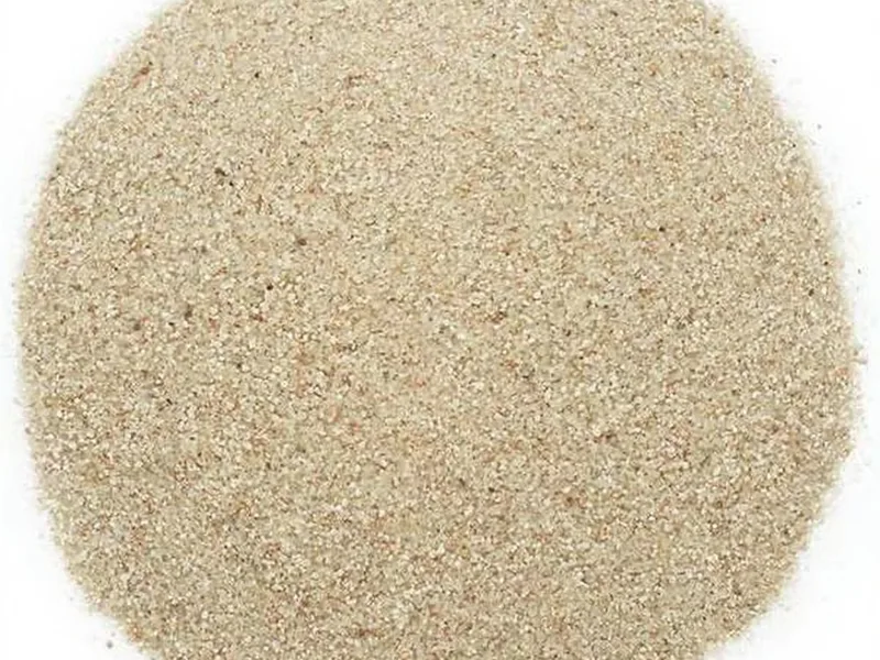 Detalle de arena de sílice de alta pureza de Esencia Marina en un fanal de vela, mostrando su textura y color natural