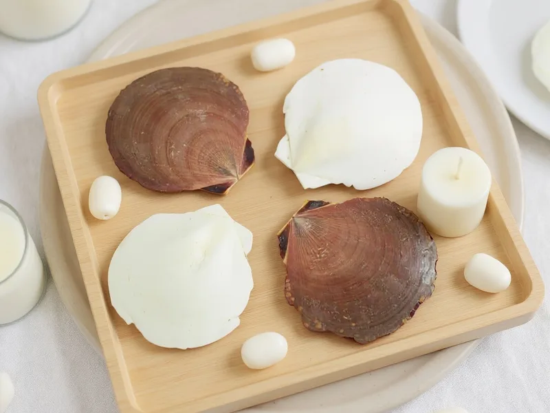 Centro de mesa costero moderno con conchas de mar sol y luna, velas y arena en tonos neutros.